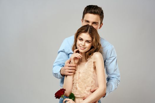 Cheerful young couple romance embrace relationship red rose lifestyle light background
