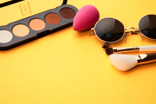 Eyeshadow makeup brushes soft sponge glasses yellow background