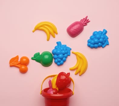 plastic childrens toys in the form of fruit and a bucket on a pi