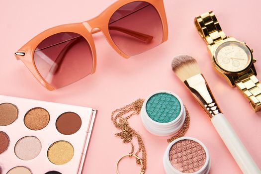 cosmetics on pink background eyeshadow brush powder blush clock