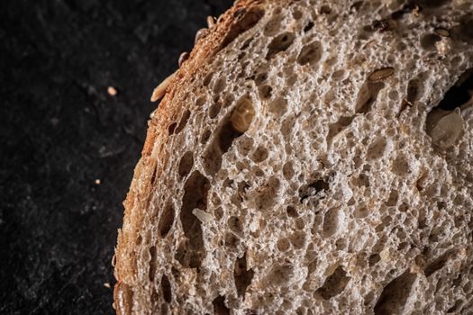 Fresh whole grain seeded bread, organic wheat flour, closeup sli