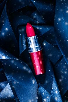 Red lipstick on blue silk and shiny glitter background, luxury m