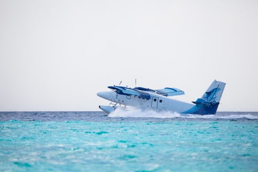 Seaplane is landing on water near an island