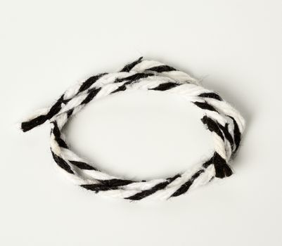 white-black rope on a white background twisted into a loop