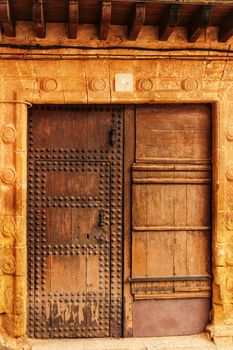 Old colorful carved wooden door with forged details in Spain