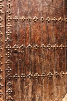 Old colorful carved wooden door with forged details in Spain