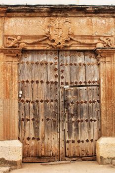 Old wooden door and coat of arms of the Holy Inquisition