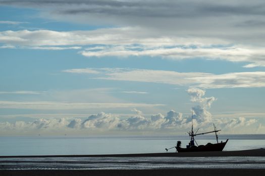 Fishing vessel with beautiful cloud sky on the beach in the morn