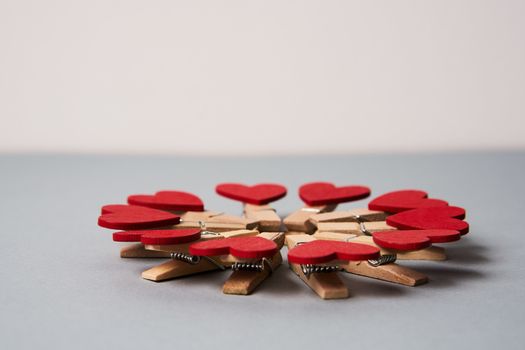 Clothespins with wooden hearts at the end on a gray background Valentine's day holidays decoration