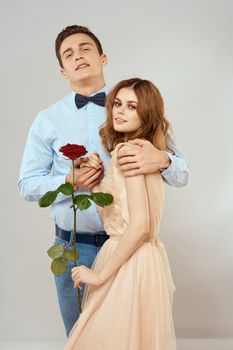 Young couple hugs romance dating lifestyle relationship light background red rose. High quality photo