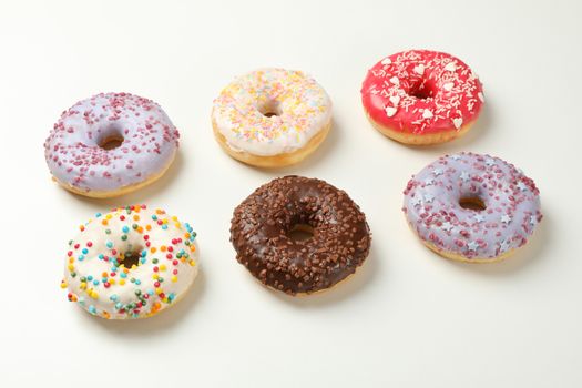 Flat lay with tasty donuts on white background