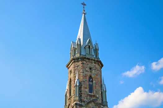 The spire of the old church against the blue sky.