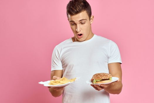 man with hamburger and fries fast food calories pink background fresh food emotion model