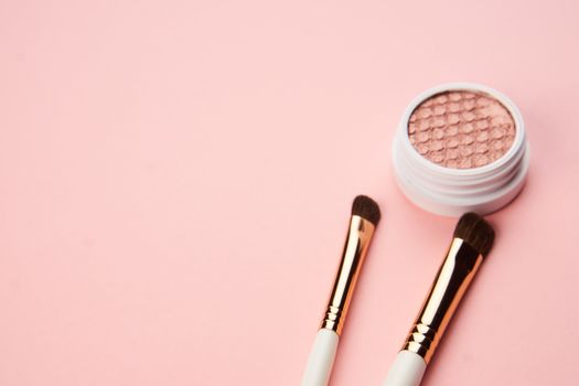 makeup brushes and eyeshadow professional cosmetics on pink background
