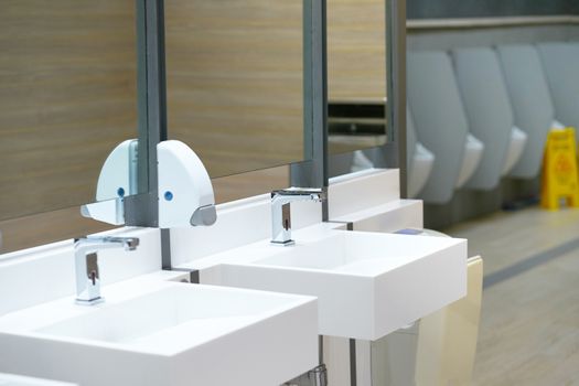 Sink in toilet with blur urinal and awareness board