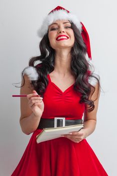 Santa girl with wish list and pencil