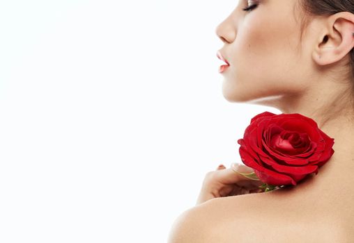 sexy woman with red flower on shoulder on light background cropped back view