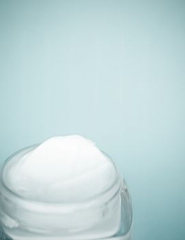 Face cream moisturizer jar on mint background, moisturizing skin