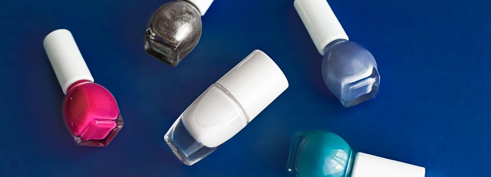 Nail polish bottles on dark blue background, beauty brand