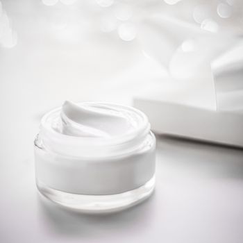 Facial cream moisturizer jar on holiday glitter background, mois
