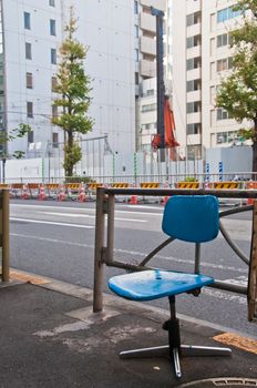 Abandoned simple blue office chair on a street alone in the morning