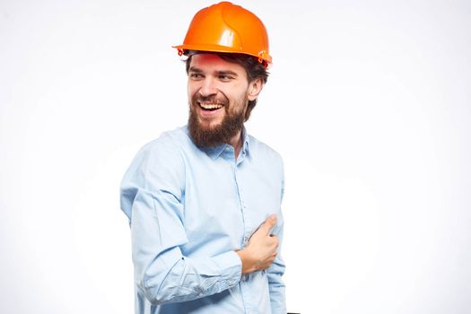 Cheerful man orange hard hat work industry professional lifestyle light background