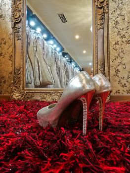 Silver shiny high-heeled shoes stiletto on red carpet in wedding