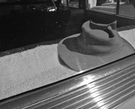 Men hat left inside car windshield in black and white