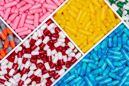 Top view of colorful capsule pills in plastic tray. Pharmaceutic