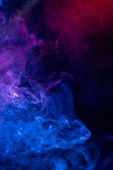 Conceptual image of colorful red and blue color smoke on dark bl