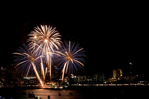 Many flashing fireworks with night cityscape background celebrat