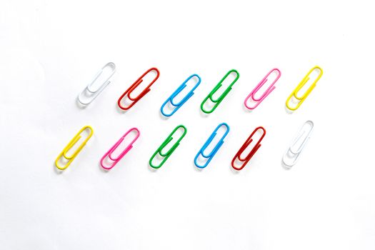 Colorful paperclips on white background.