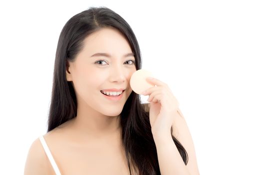 Portrait of beautiful asian woman applying powder puff at cheek 