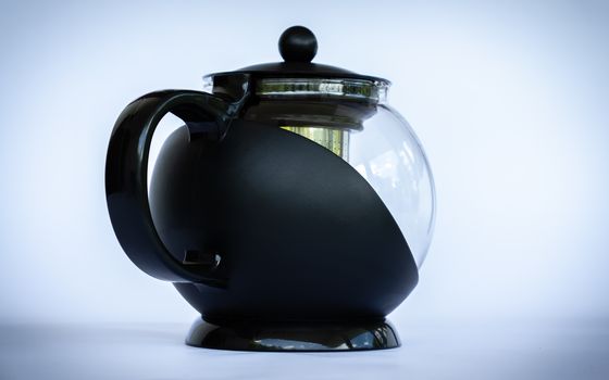 Black glass coffee pot in neutral background angled side view