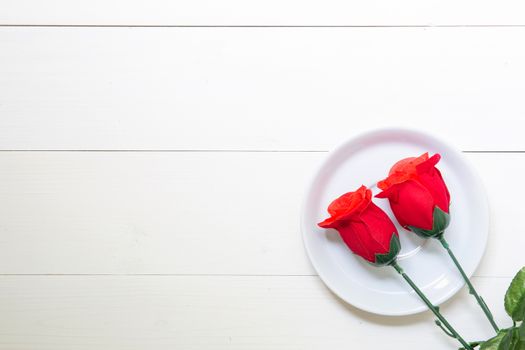 Present gift with red rose flower and dish on wooden table, 14 F