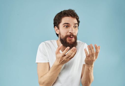 Puzzled man with a beard on a blue background emotions of surprise