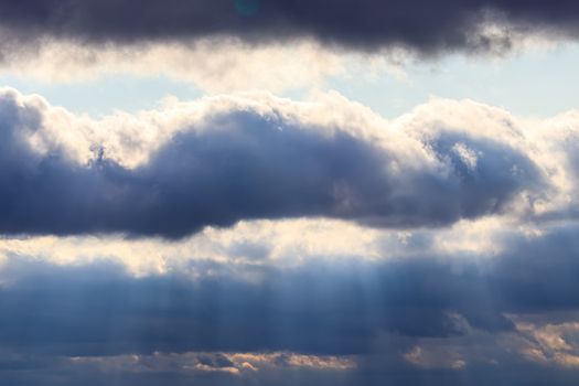 Sun rays breaking through cumulus clouds. The concept of divine light, a glimmer of hope or overcoming difficulties. Spiritual religious abstract backdrop.