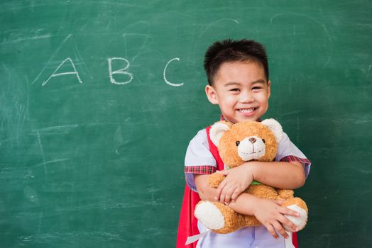 Child boy from kindergarten in student uniform with school bag s