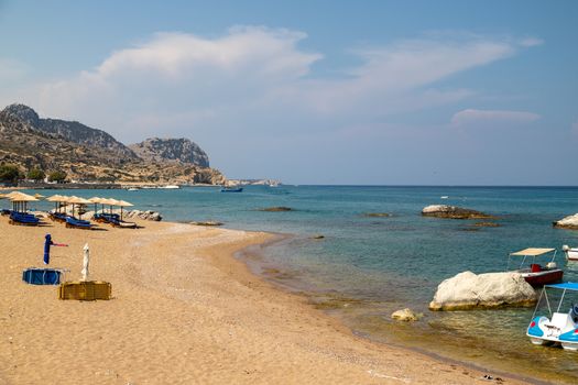 Stegna beach on Greek island Rhodes with sand, sunshades and boa