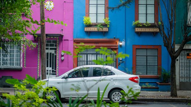 White Car Parked Outside Two Colorful Houses From the Neighbourhood of Coyoacan