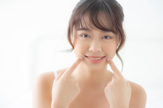 Beautiful portrait young asian woman smiling healthy and wellness at bedroom, beauty asia girl skin care touch teeth makeup and cosmetic with happy with fresh, lifestyle and relax concept.