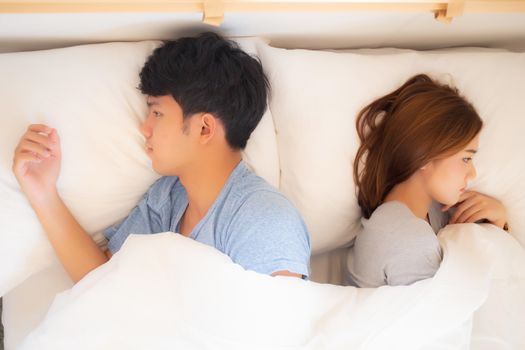 Young asian couple lying separate and failure on bed at home, as