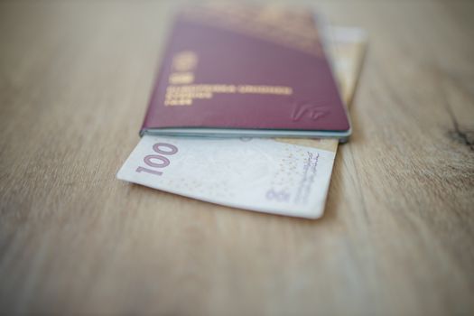 100 Moroccan Dirhams Bill Partially Inside a Sweden Passport