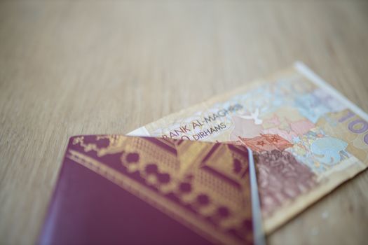 100 Moroccan Dirhams Bill Partially Inside a Sweden Passport