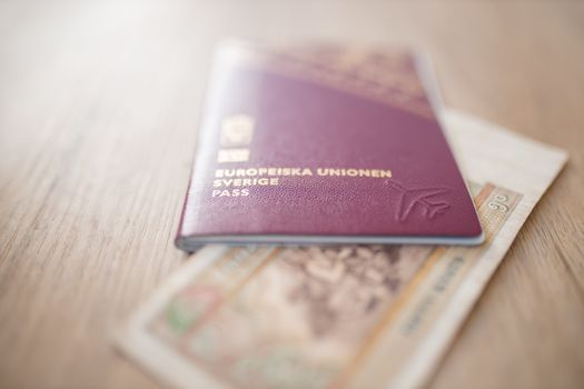 Sweden Passport with a Fifty Burmese Kyats Bill Partially Inside