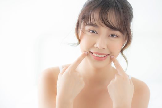 Beautiful portrait young asian woman smiling healthy and wellness at bedroom, beauty asia girl skin care touch teeth makeup and cosmetic with happy with fresh, lifestyle and relax concept.