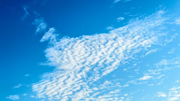 Cloudy sky background. Blue sky clouds background. Aesthetic blue sky wallpaper. Beautiful Cloudscape photography in summer. Tranquility theme. Copy space room for text in the middle of the Image.
