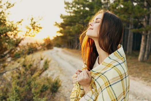woman with closed eyes in plaid blanket fresh air nature enjoyment