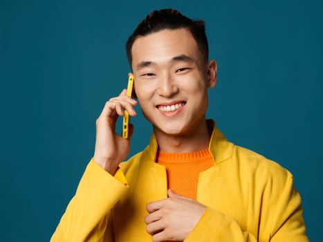 Happy male asian appearance korean blue background mobile phone
