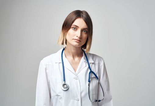 Professional doctor woman with blue stethoscope and white medical gown